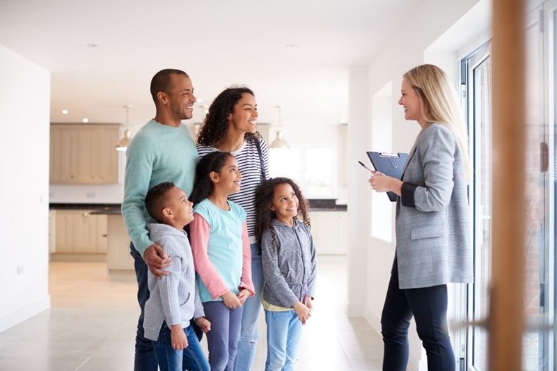 Family viewing home with real estate agent